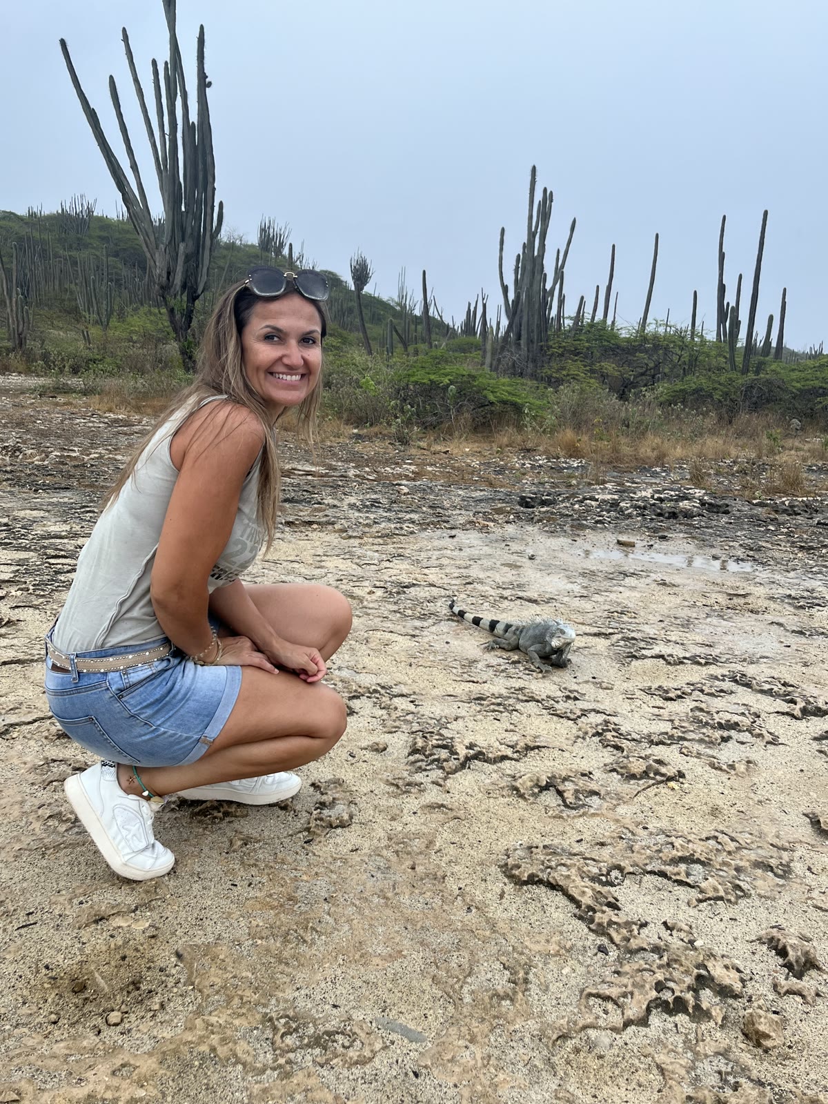 Martina naast een leguaan tussen de cactussen